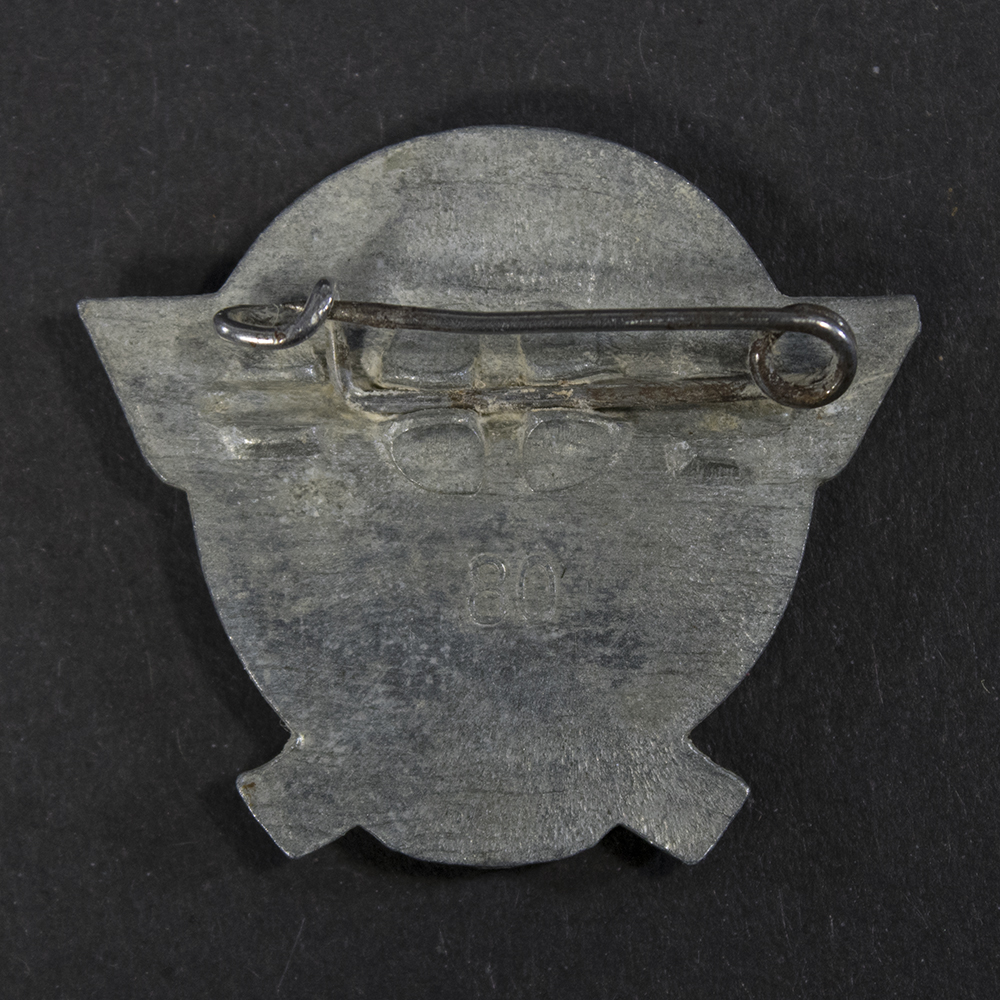 Back side of the WWII German WHW ‘Tag der Deutschen Polizei 1942’ tinnie, showing the plain reverse surface and horizontal pin fastener.