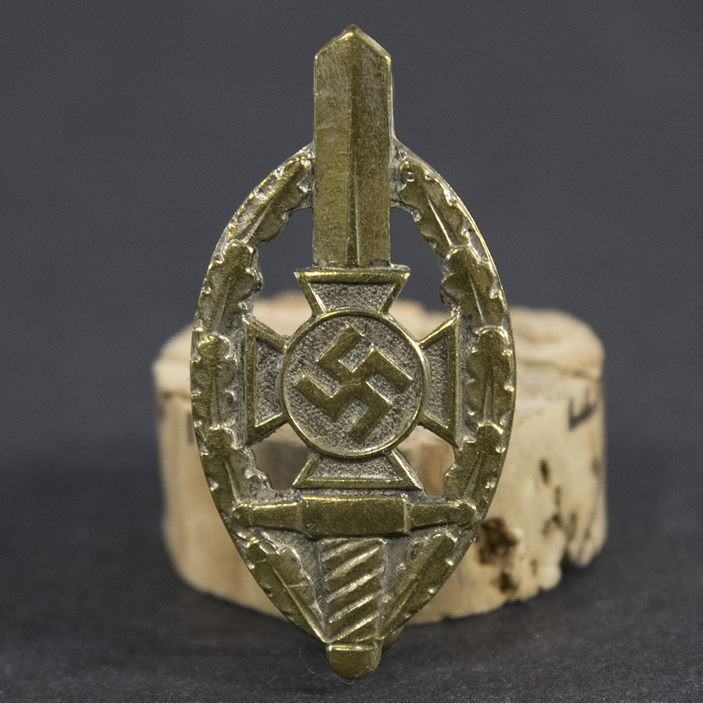 Close-up of the front of a WWII German NSKOV membership pin, showing the detailed enamel emblem and lettering.