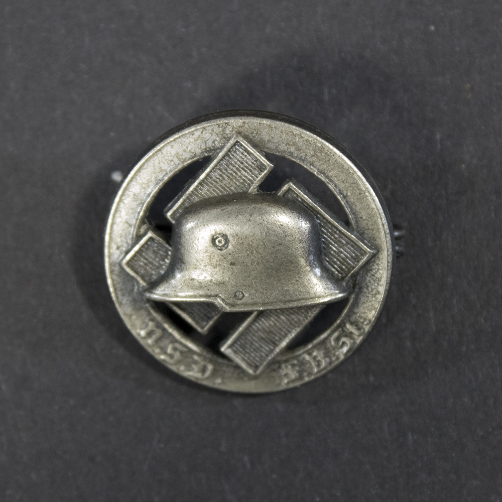 WWII German N.S.D.F.B.St membership pin displayed flat, showing its oval badge with detailed emblem and attached stick pin.