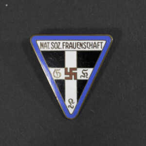 WWII German Nat.Soz.Frauenschaft Ortsgruppe membership badge displayed flat, showing its oval shape with detailed emblem and attached pin.
