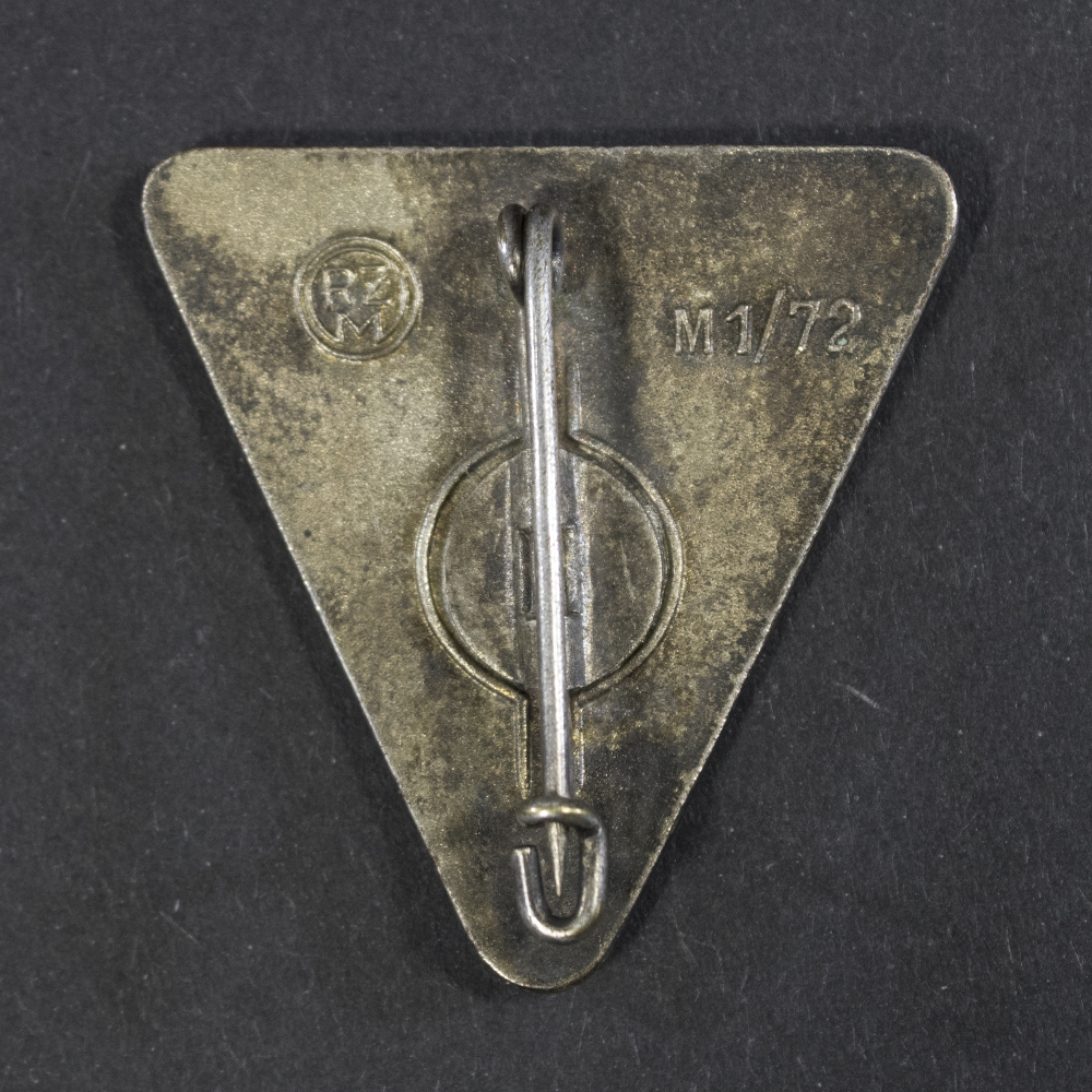 Back side of the WWII German Deutsches Frauenwerk badge, showing the smooth reverse surface and pin attachment mechanism.