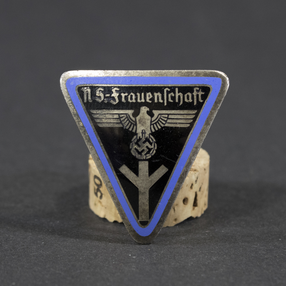 WWII German NS Frauenschaft Ortsgruppe staff badge displayed flat, showing its oval shape with detailed emblem and attached pin.