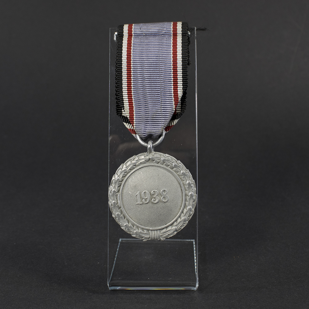 WWII German Luftschutz medal displayed flat, showing its circular shape with detailed embossed design and attached suspension ring.