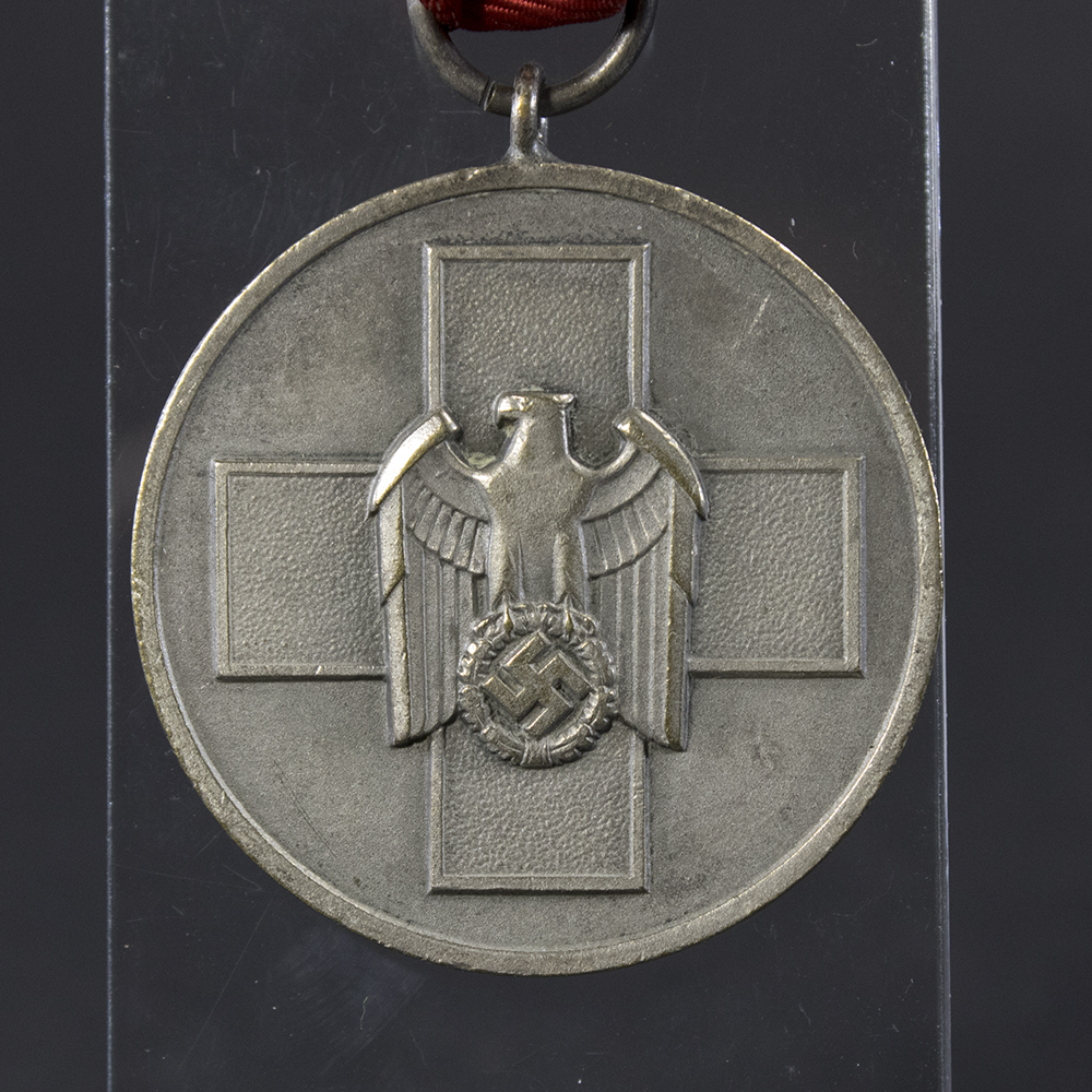 Close-up of the front side of the WWII German Volkspflege Medal, highlighting the intricate emblem and raised lettering.