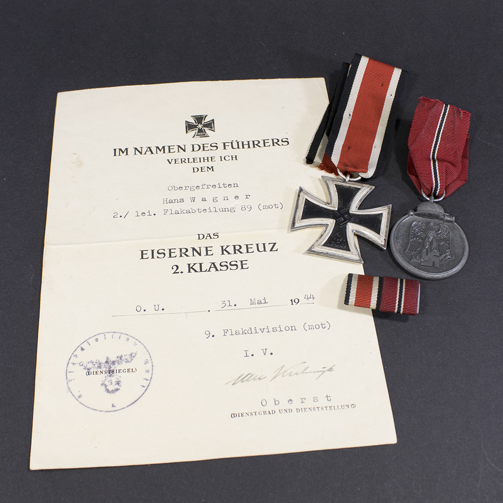 Overview of a WWII Iron Cross 2nd Class and Eastern Front Medal set, displayed together with ribbon bar and award document.