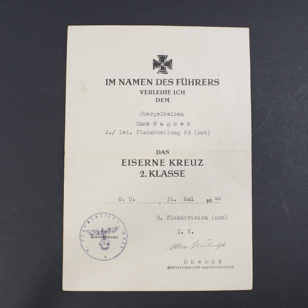 Close-up of the front of a WWII Iron Cross 2nd Class award document, showing printed text and recipient details.