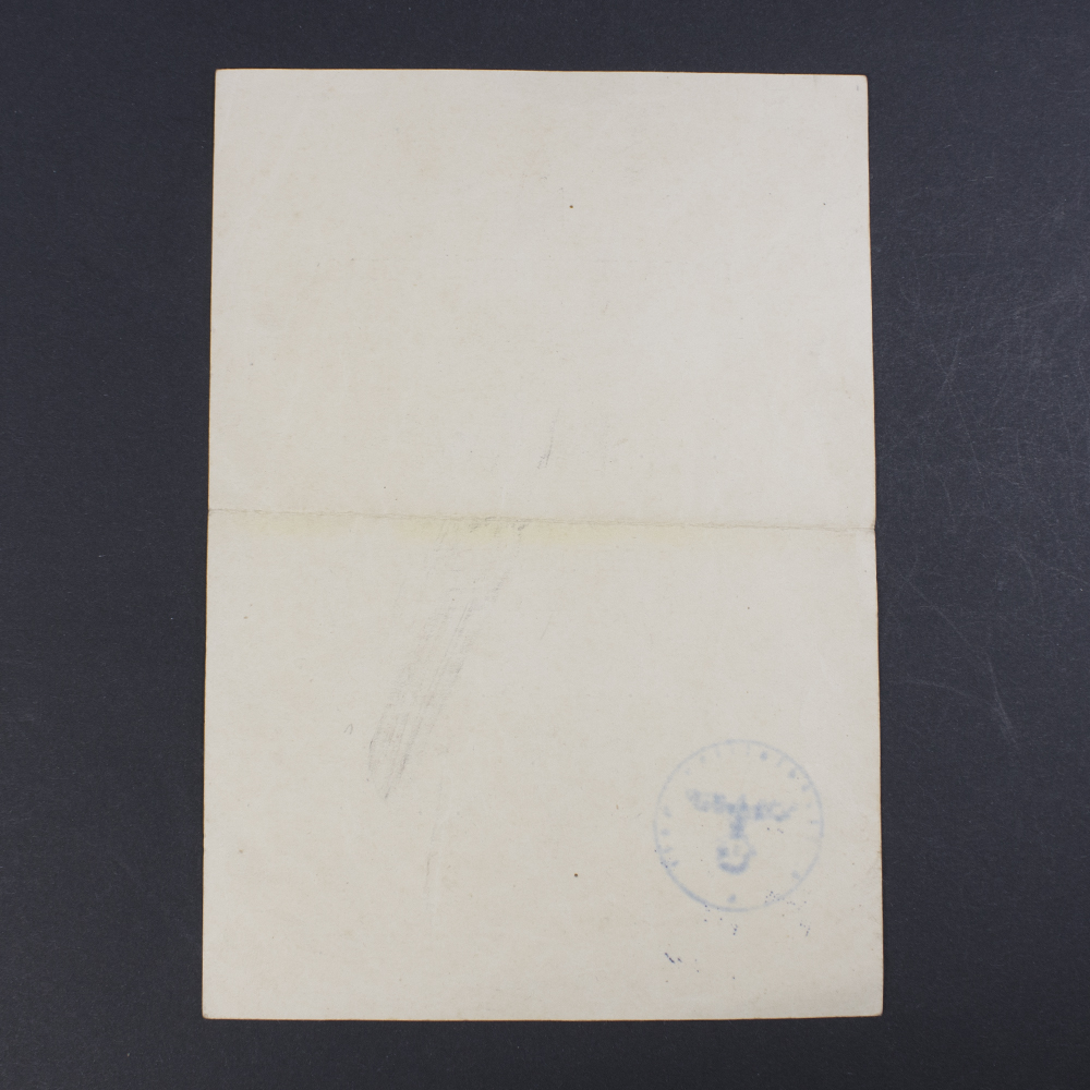 Close-up of the reverse of a WWII Iron Cross 2nd Class award document, showing paper texture and wear.