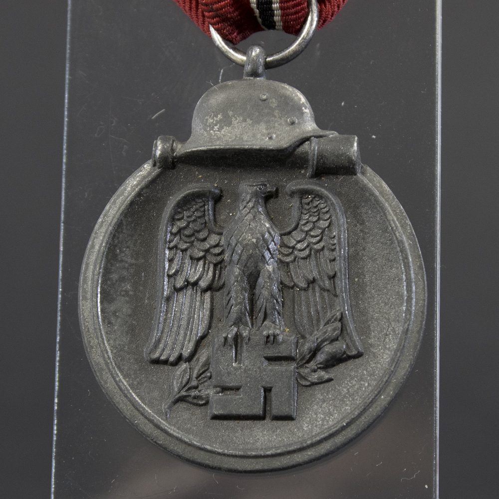 Close-up of the front of a WWII Eastern Front Medal, showing the detailed relief design.