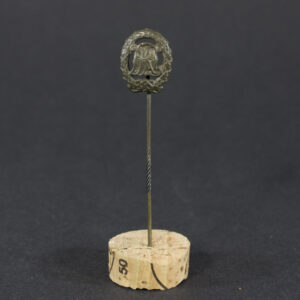 World War II German Bronze DRL stick pin displayed flat, showing its oval badge with intertwined letters and attached pin.