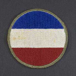 Front of WWII U.S. Army Ground Forces patch with green backing, showing shield shape and emblem in good condition.