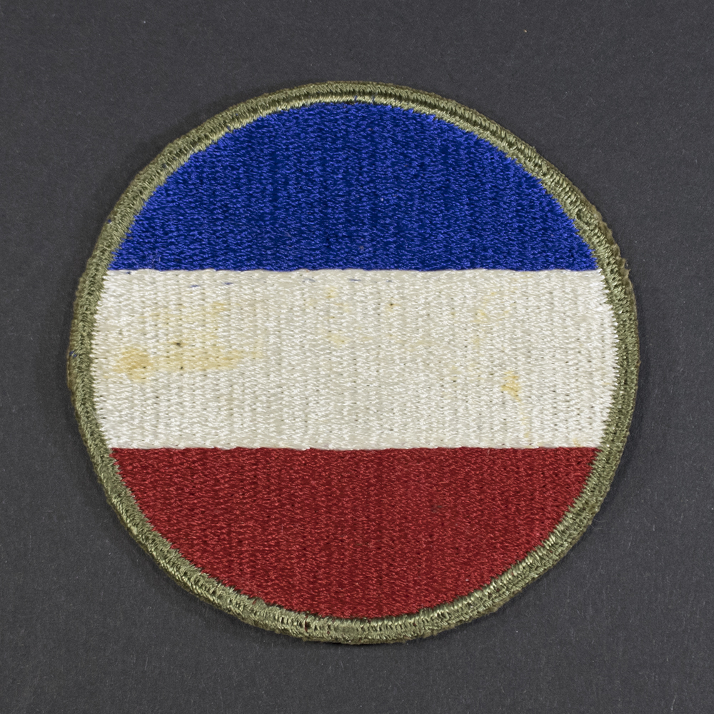 Front of WWII U.S. Army Ground Forces patch with green backing, showing shield shape and emblem in good condition.