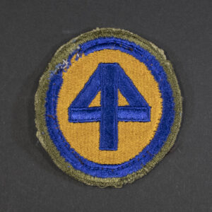 Front of WWII U.S. Army 44th Infantry Division patch, featuring blue and red design on olive background in good condition.