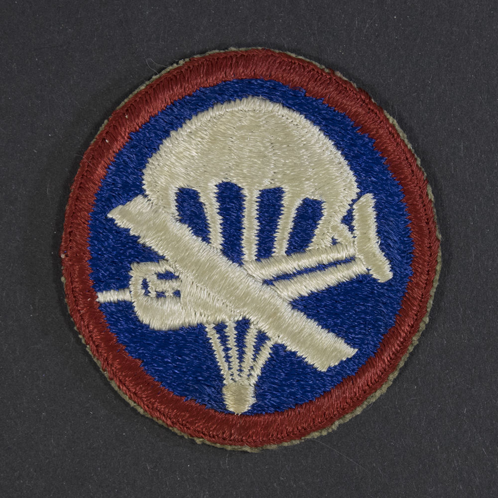 Front of WWII U.S. Army enlisted men’s combined glider and parachute cap patch, showing winged parachute and glider emblem in good condition.