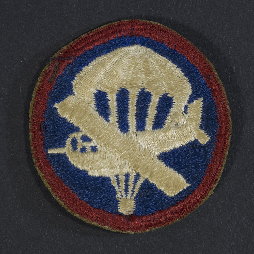 Front of WWII U.S. Army enlisted men’s combined glider and parachute cap patch, showing winged parachute and glider emblem in good condition.