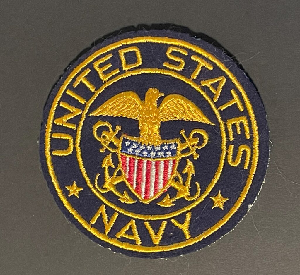 Front of WWII United States Navy patch, featuring blue background with gold anchor and rope design in good condition.