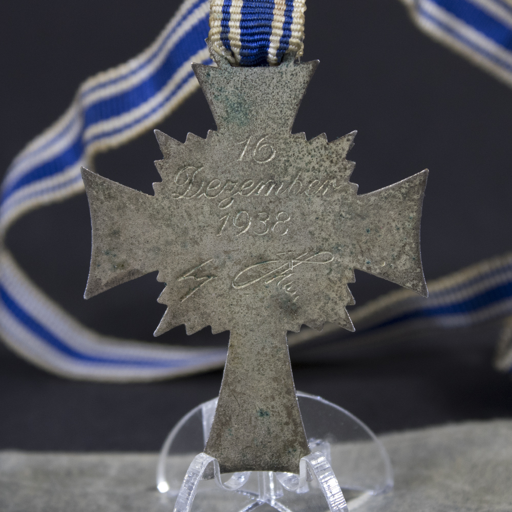 Close-up of the reverse of the WW2 German Silver Mother’s Cross, displaying the inscription 'Der Deutschen Mutter' and the engraved maker details around the center.