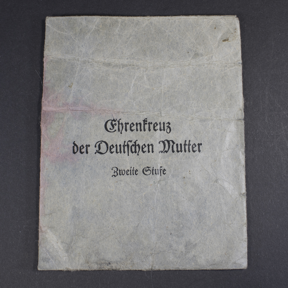 Front view of the dark blue presentation bag for the WW2 German Mother’s Cross, featuring its flap closure and textured fabric surface