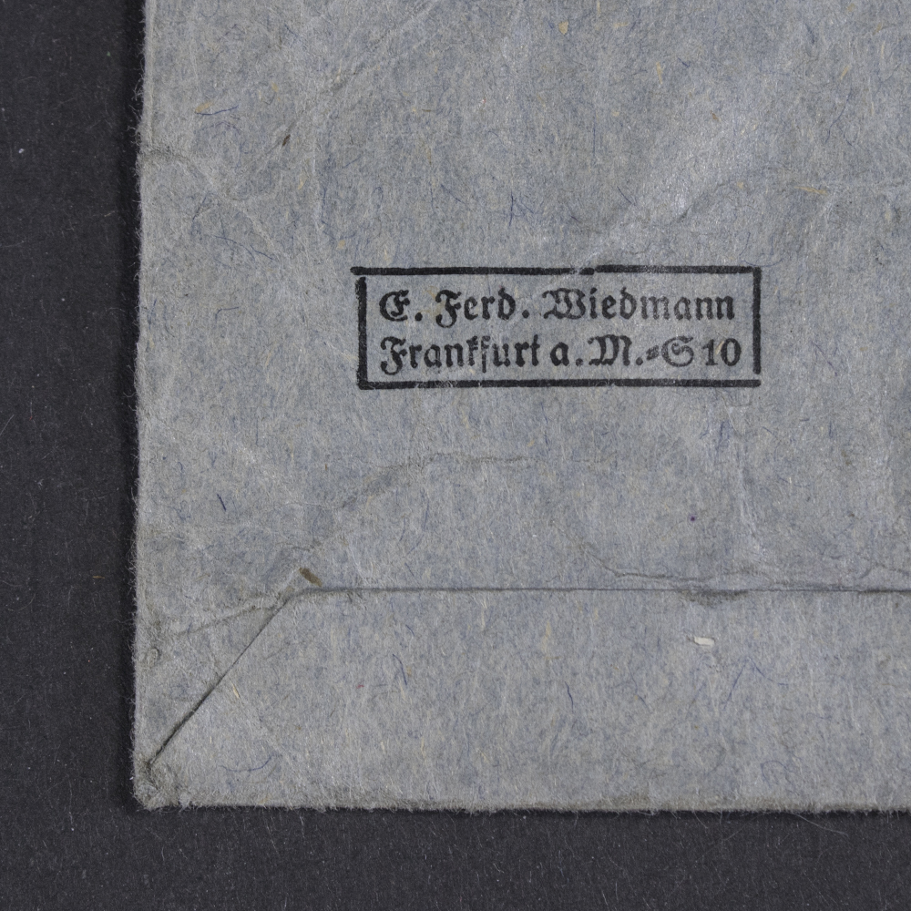 Close-up of the maker mark 'Ferd. Wiedmann' stamped on the back of the presentation bag, showing the manufacturer’s name clearly impressed into the material.