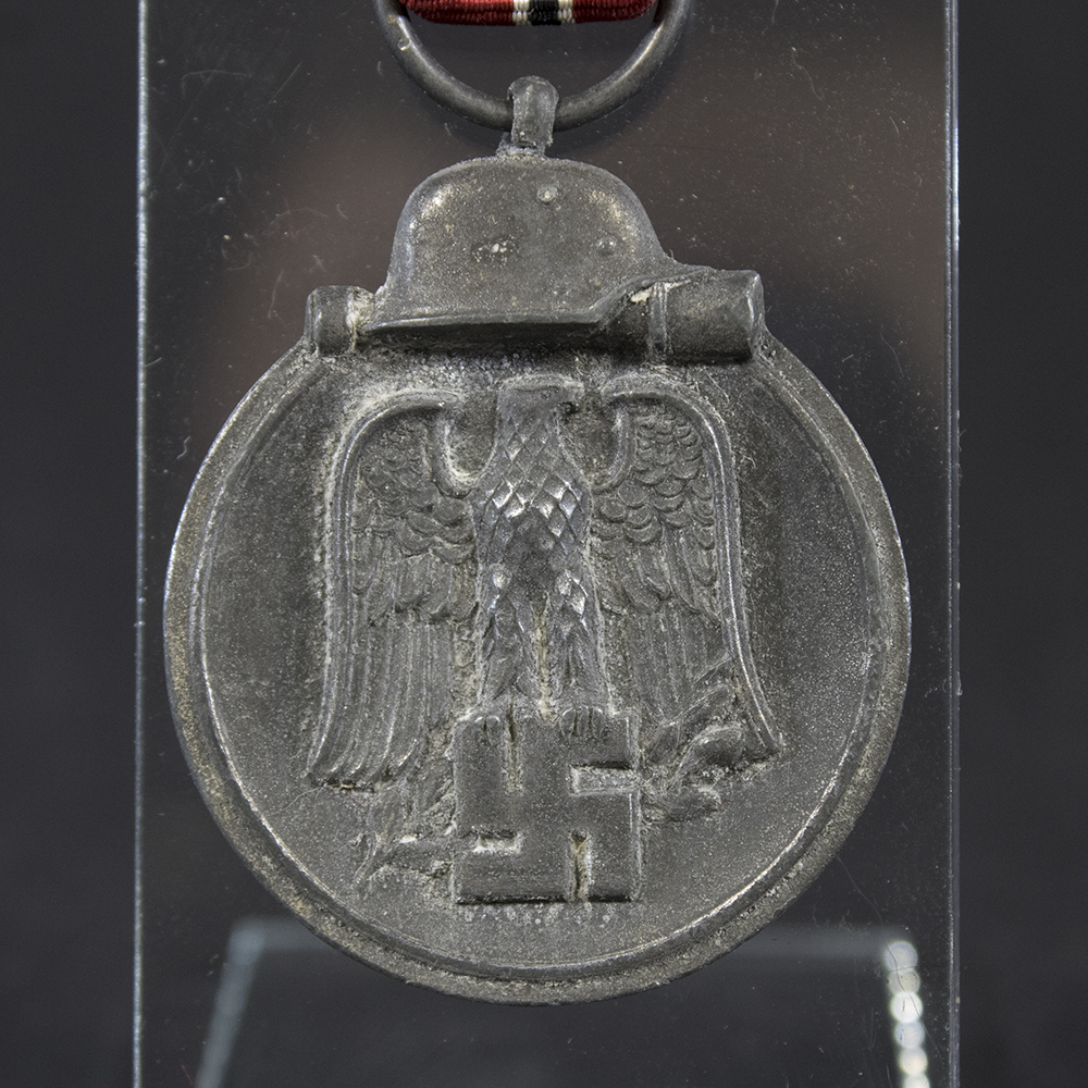 Close-up of the front of a WW2 German Eastern Front Medal, featuring the central Wehrmacht eagle above a swastika and the surrounding wreath design.
