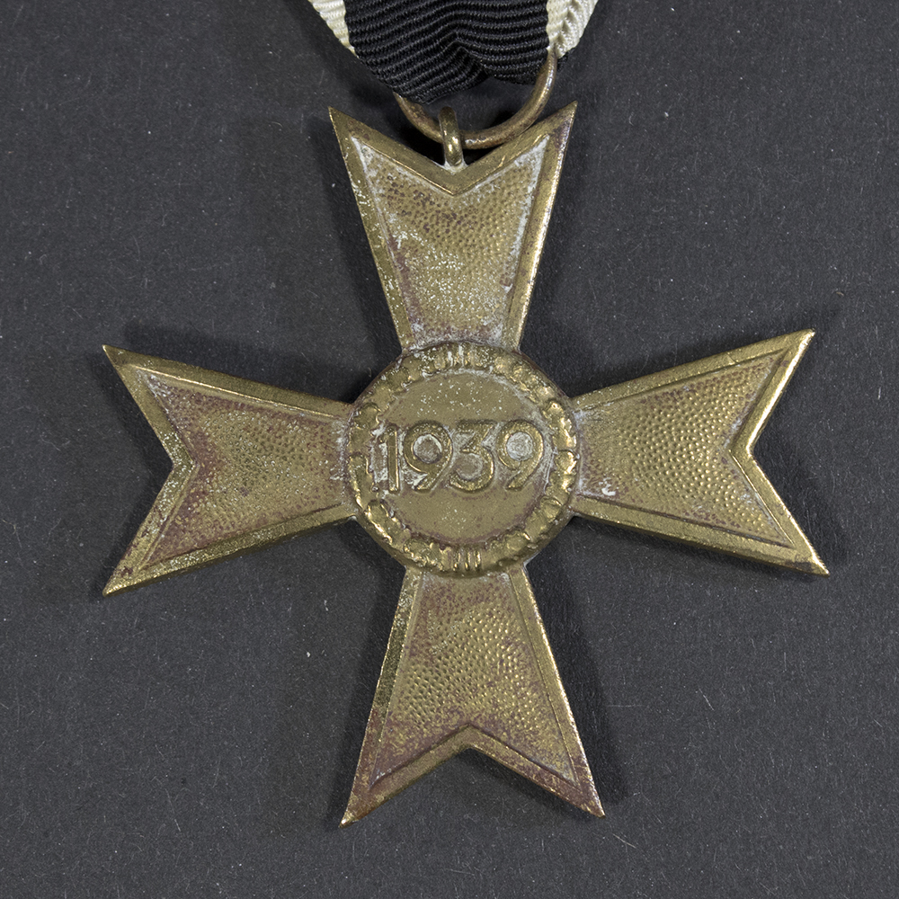 Close-up of the reverse side of the War Merit Cross without Swords, showing the smooth center with the raised ‘1939’ inscription and the textured bronze finish,