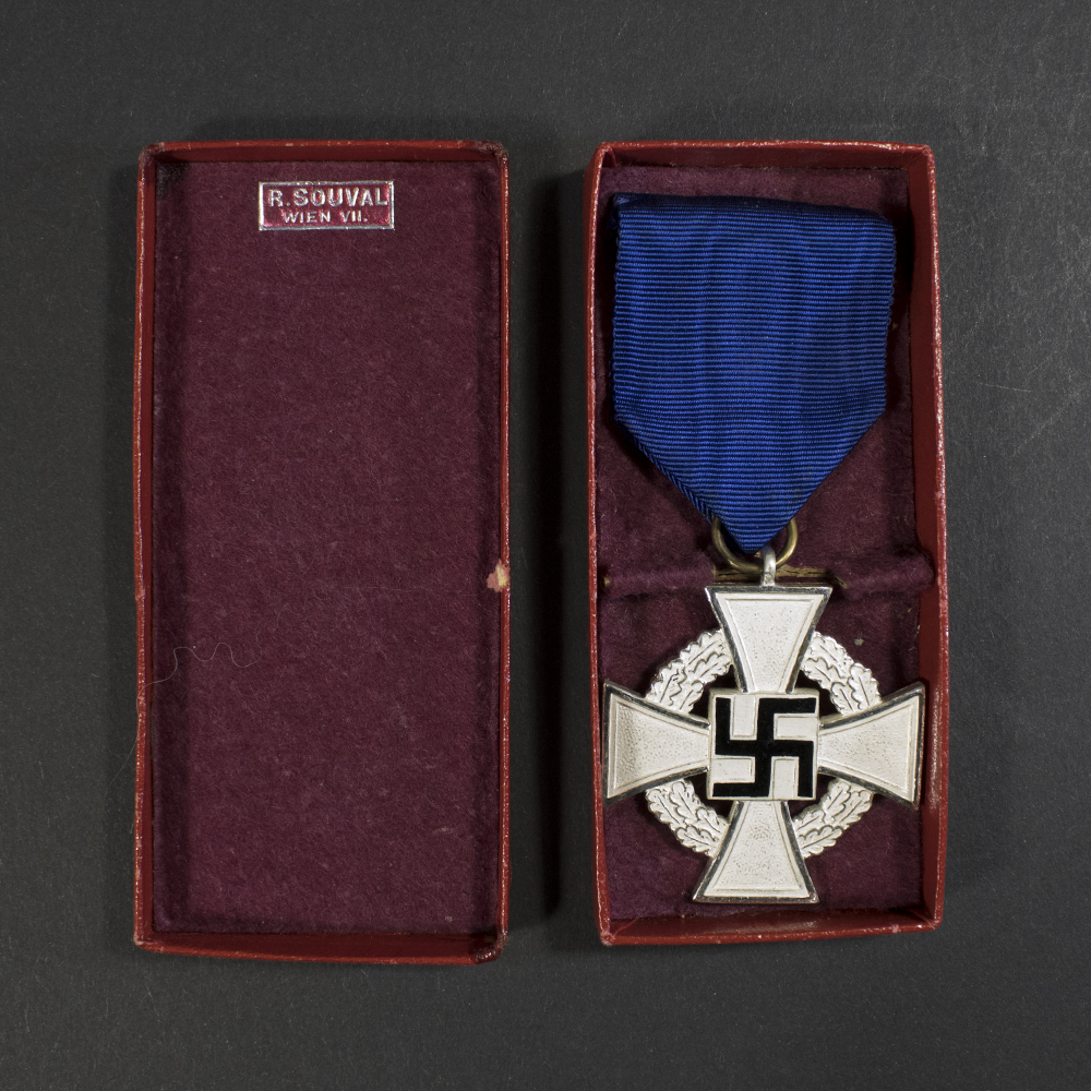 Front view of a German WW2 Faithful Service Medal in silver finish displayed inside its open presentation case, showing the silver cross with dark blue center and attached ribbon.