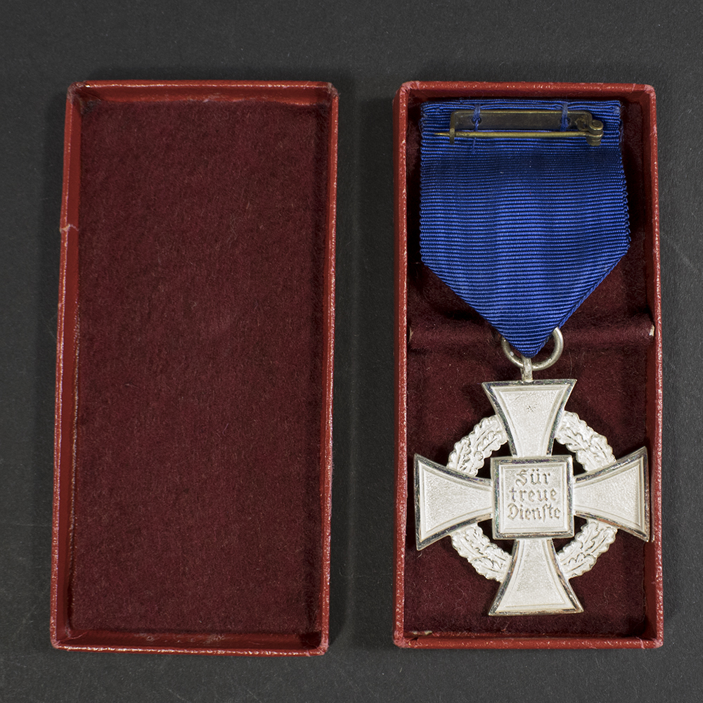 Overview of a WWII German Faithful Service Medal with its original case, showing the front and back of the medal side by side.