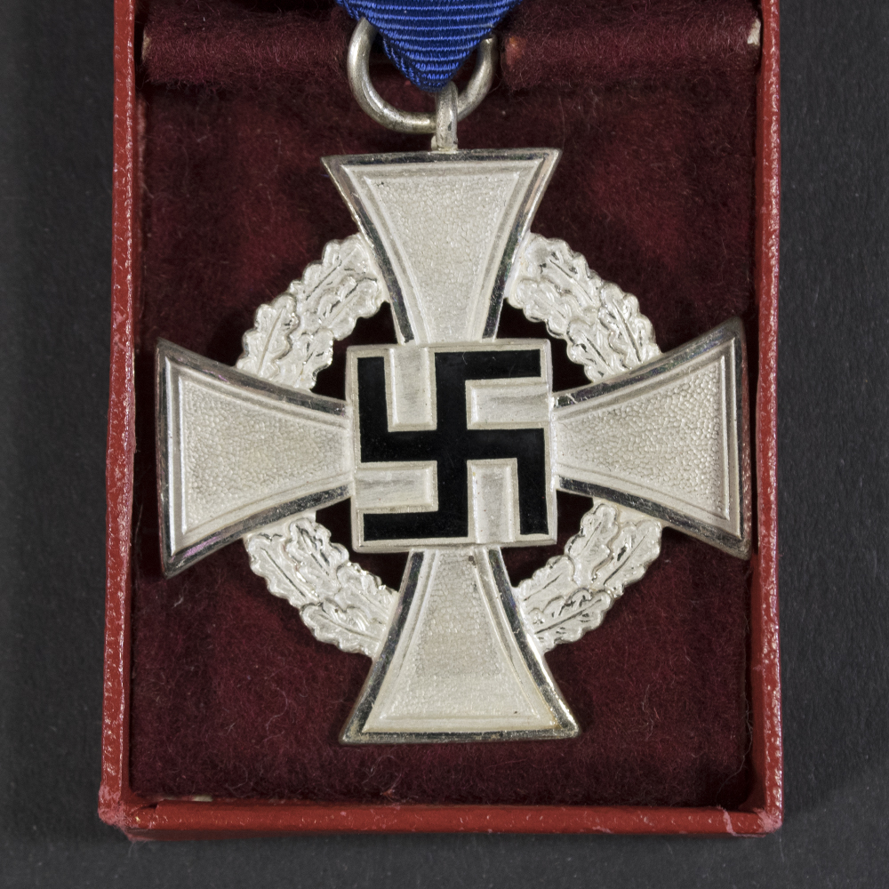 Close-up of the front of a WWII German Faithful Service Medal, showing the circular metal design and central emblem in detail.