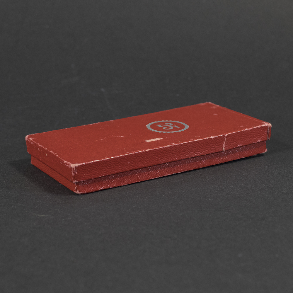 Open presentation case containing a WWII German Faithful Service Medal, with the medal seated inside against the fitted interior.