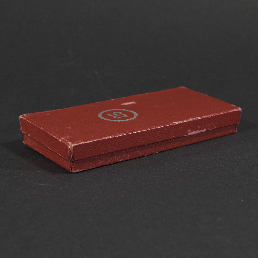 Angled view of the closed original case for a WWII German Faithful Service Medal, showing the textured exterior and hinge.