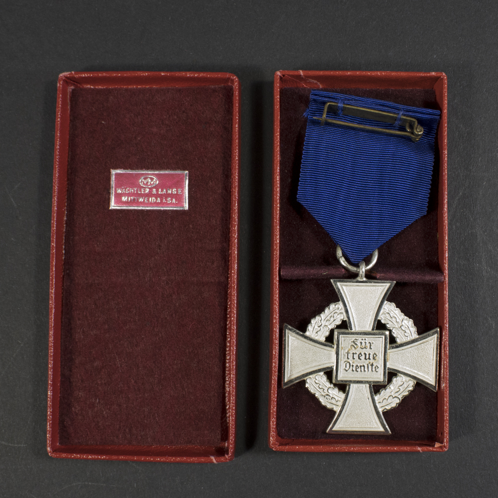 Overview of a WWII German Faithful Service Medal with its original case, showing the front and back of the medal side by side.