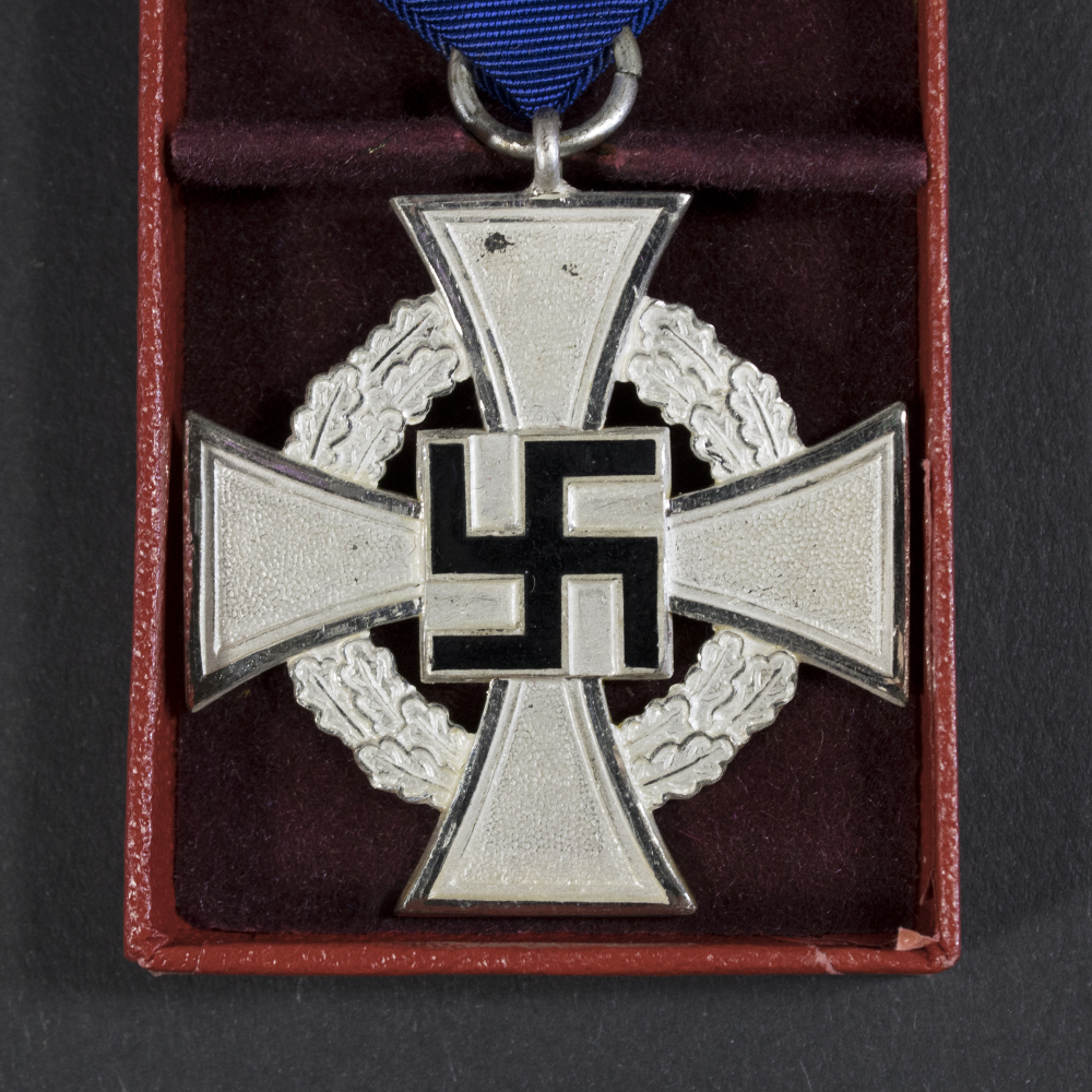 Close-up of the front of a WWII German Faithful Service Medal, showing the circular metal design and central emblem in detail.