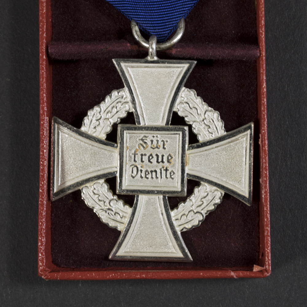 Close-up of the back of a WWII German Faithful Service Medal, showing the plain reverse surface and edge details.