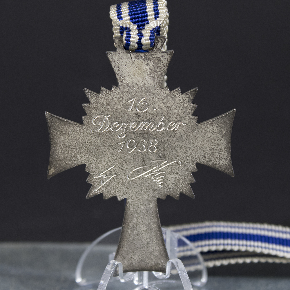 Close-up of the back of a WWII German silver Mother’s Cross, showing the inscription and suspension ring in detail.