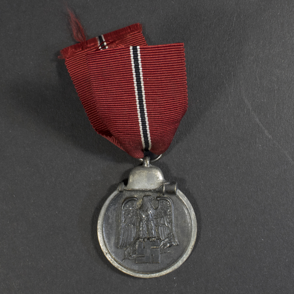 Overview of a WWII German Eastern Front Medal displayed with its original suspension ribbon.