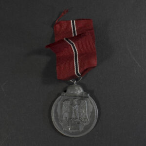 Overview of a WWII German Eastern Front Medal displayed with its original suspension ribbon.