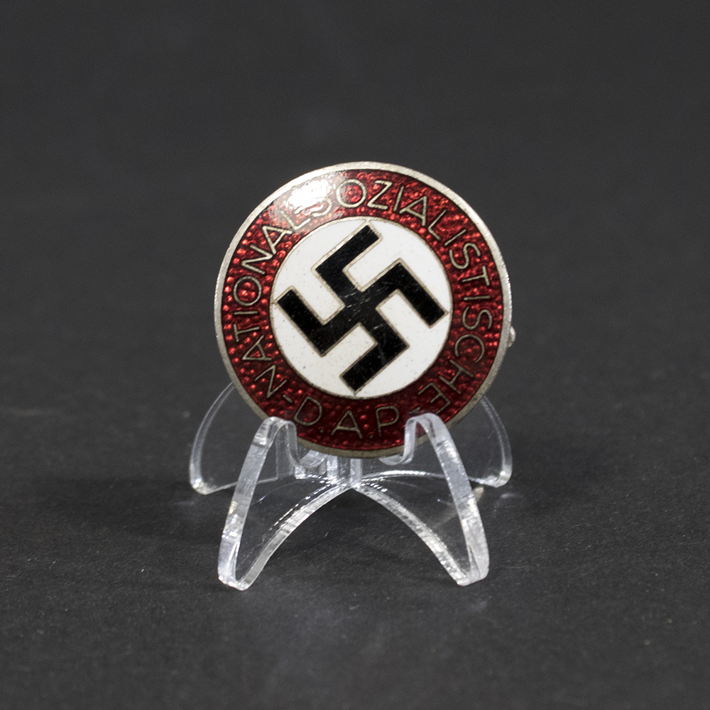 Overview of a WWII German NSDAP membership pin, showing the circular enamel badge and metal construction.