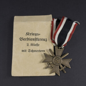 WW2-era German War Merit Cross with Swords set displayed together with its original paper issue bag.