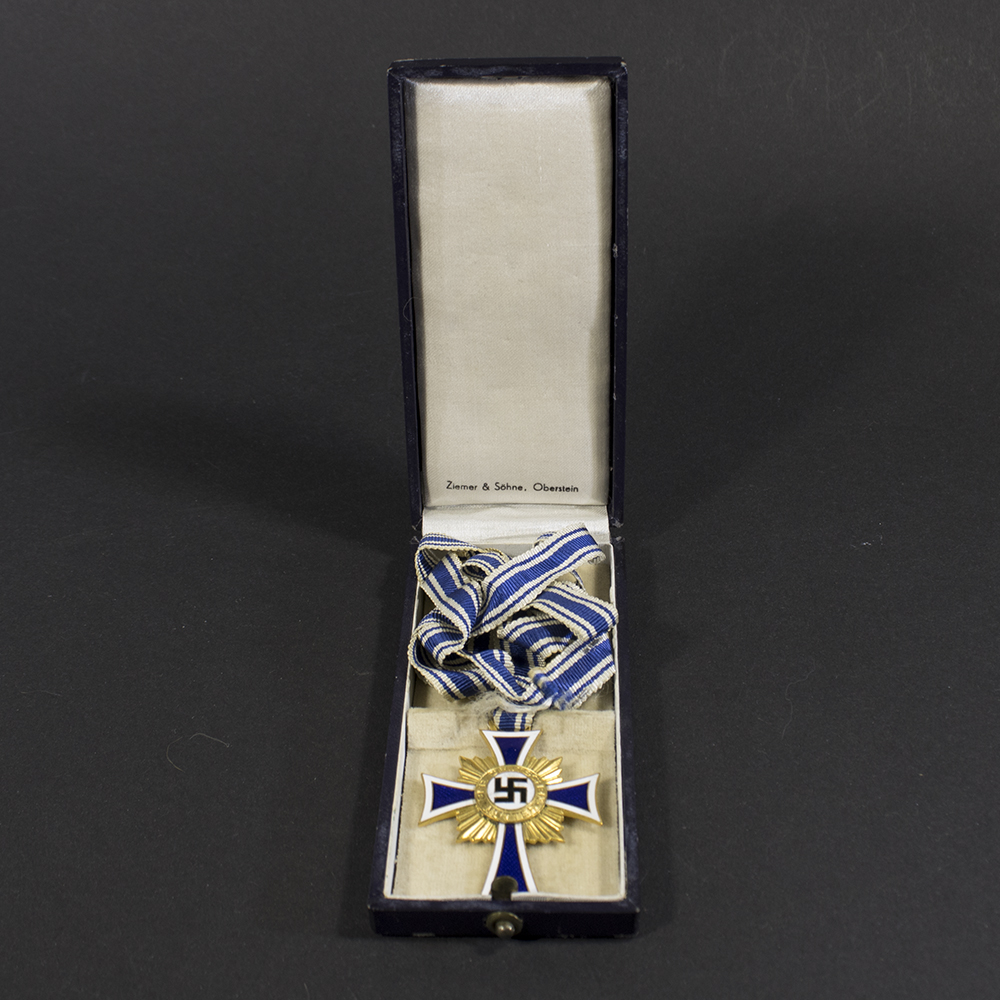 Overview of a WWII German golden Mother’s Cross displayed together with its original presentation case.