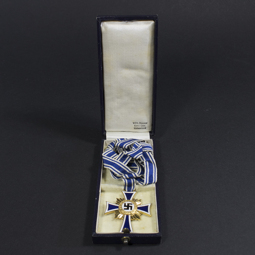 Overview of a WWII German golden Mother’s Cross displayed together with its original presentation case.
