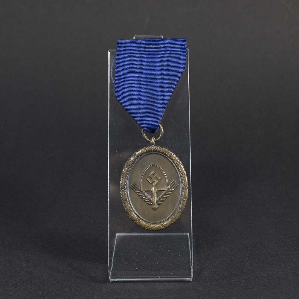 Overview of a WWII German RAD 4‑year long service medal, showing the bronze medal suspended from its original ribbon.