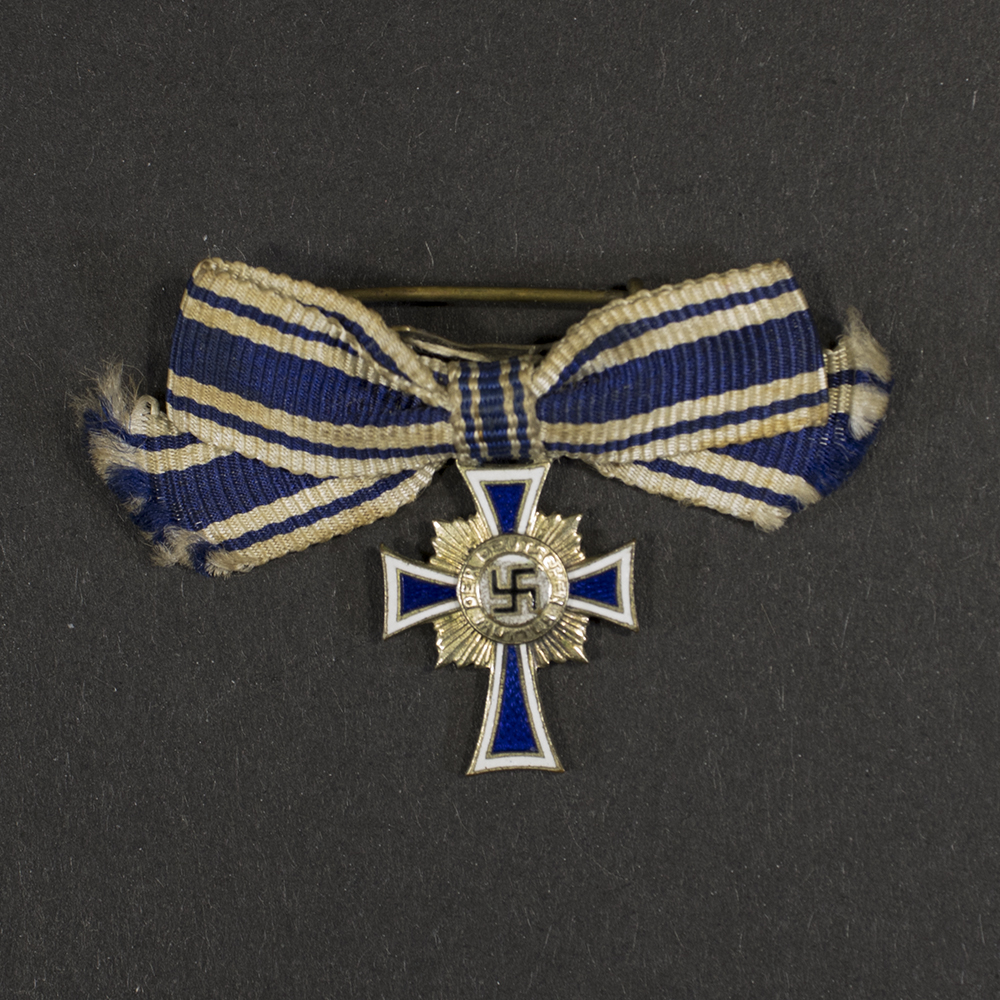 Overview of a WWII German Gold Mother’s Cross miniature, showing the complete miniature medal with ribbon.