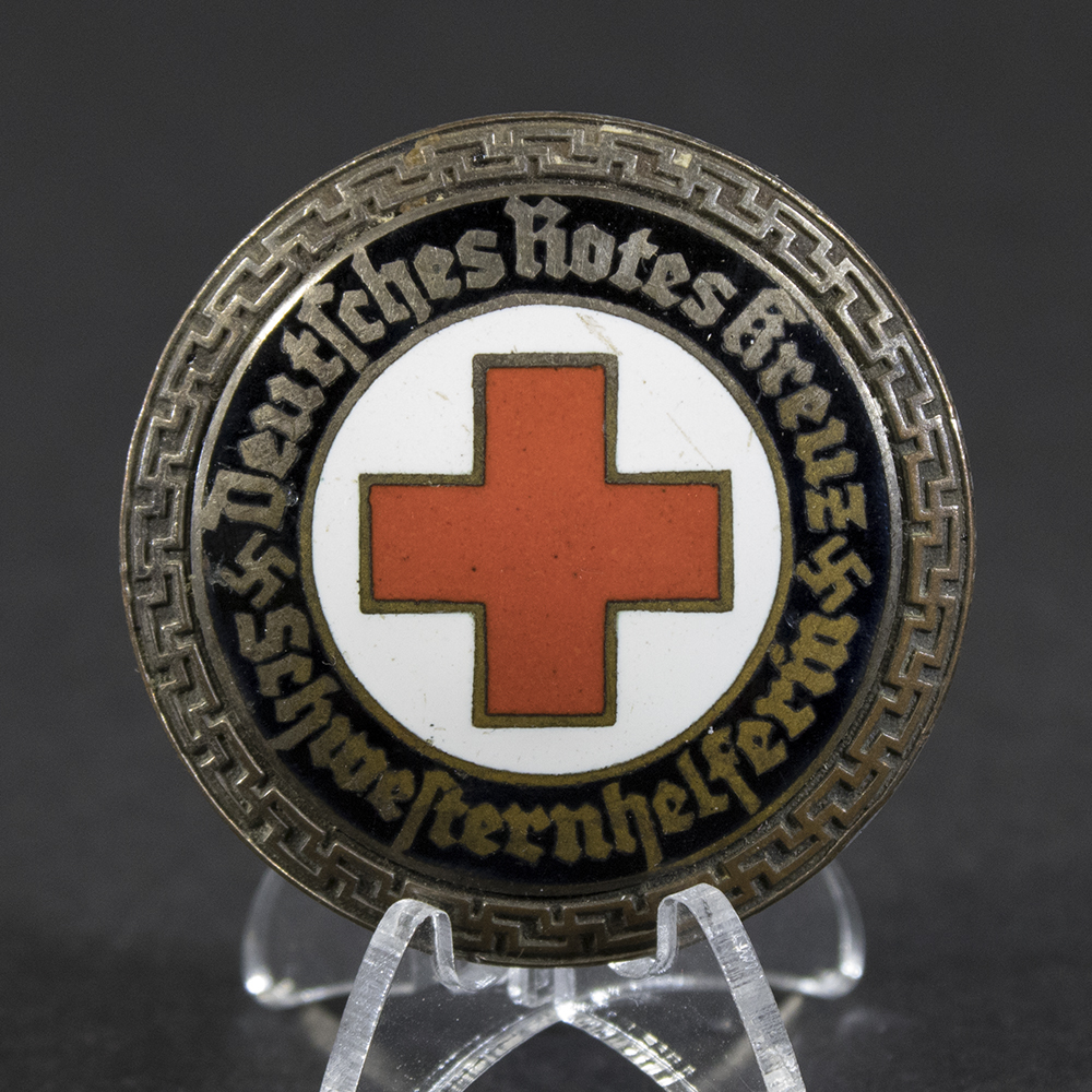 Close‑up of the front of a WWII German DRK Schwesterhelferin brooch, showing the Red Cross emblem and enamel details.