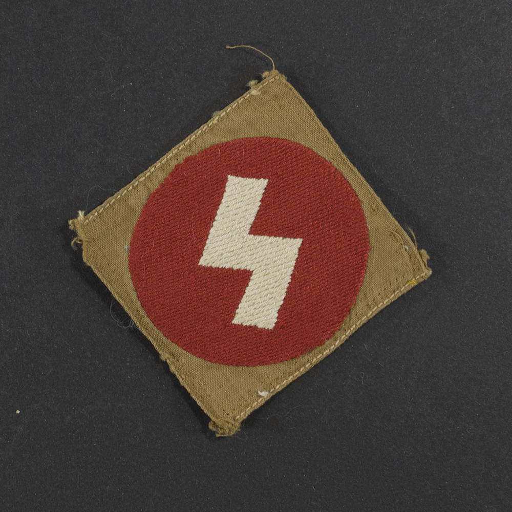 Front view of a WWII Deutsches Jungvolk cloth sleeve badge for Oberbann 1, showing the black diamond‑shaped patch with a white center stripe and the number “1” at the top. The woven texture, stitching, and fabric edges are clearly visible.