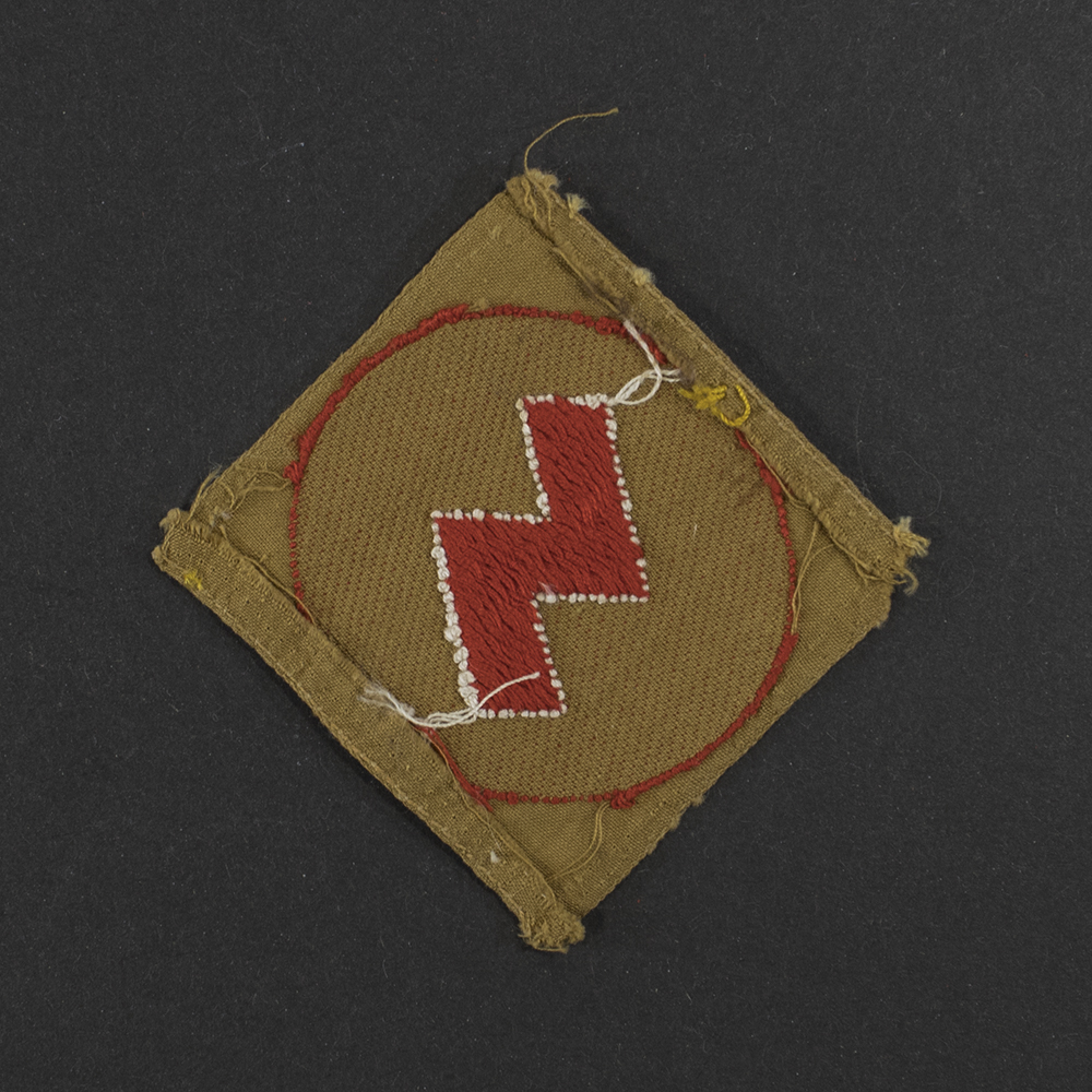 Back view of the same cloth DJ sleeve badge, showing the reverse side of the fabric with visible stitching, thread patterns, and the unfinished textile surface. The construction details and wear on the backing material are clearly visible.
