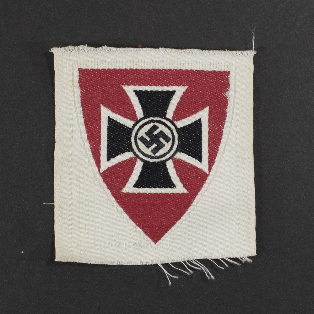 Front view of a WWII Kyffhäuserbund cloth sleeve insignia, showing the shield‑shaped patch with its embroidered design. The central motif, colors, stitching, and fabric texture are clearly visible.