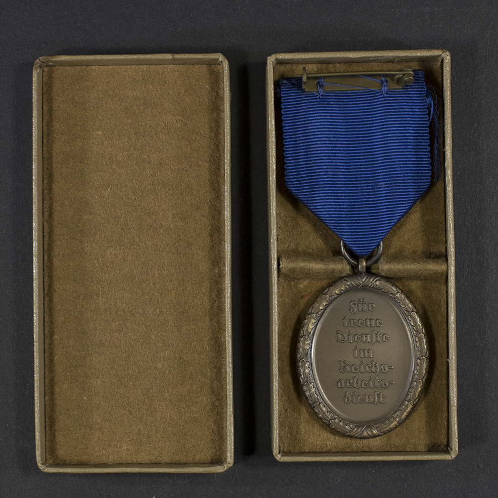 Close‑up of the open case showing the reverse of the WWII German RAD 4‑year long service medal.