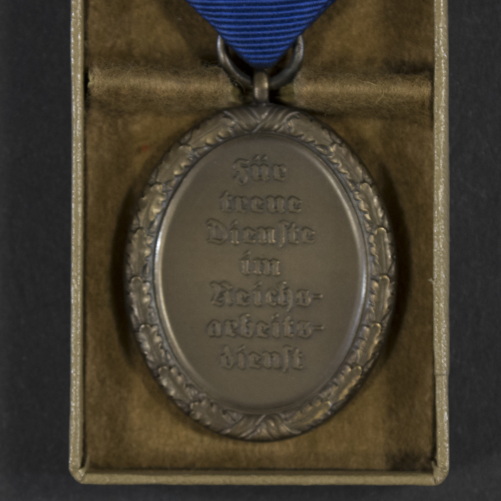 Close‑up of the reverse of the WWII German RAD 4‑year long service medal, showing the plain back and suspension