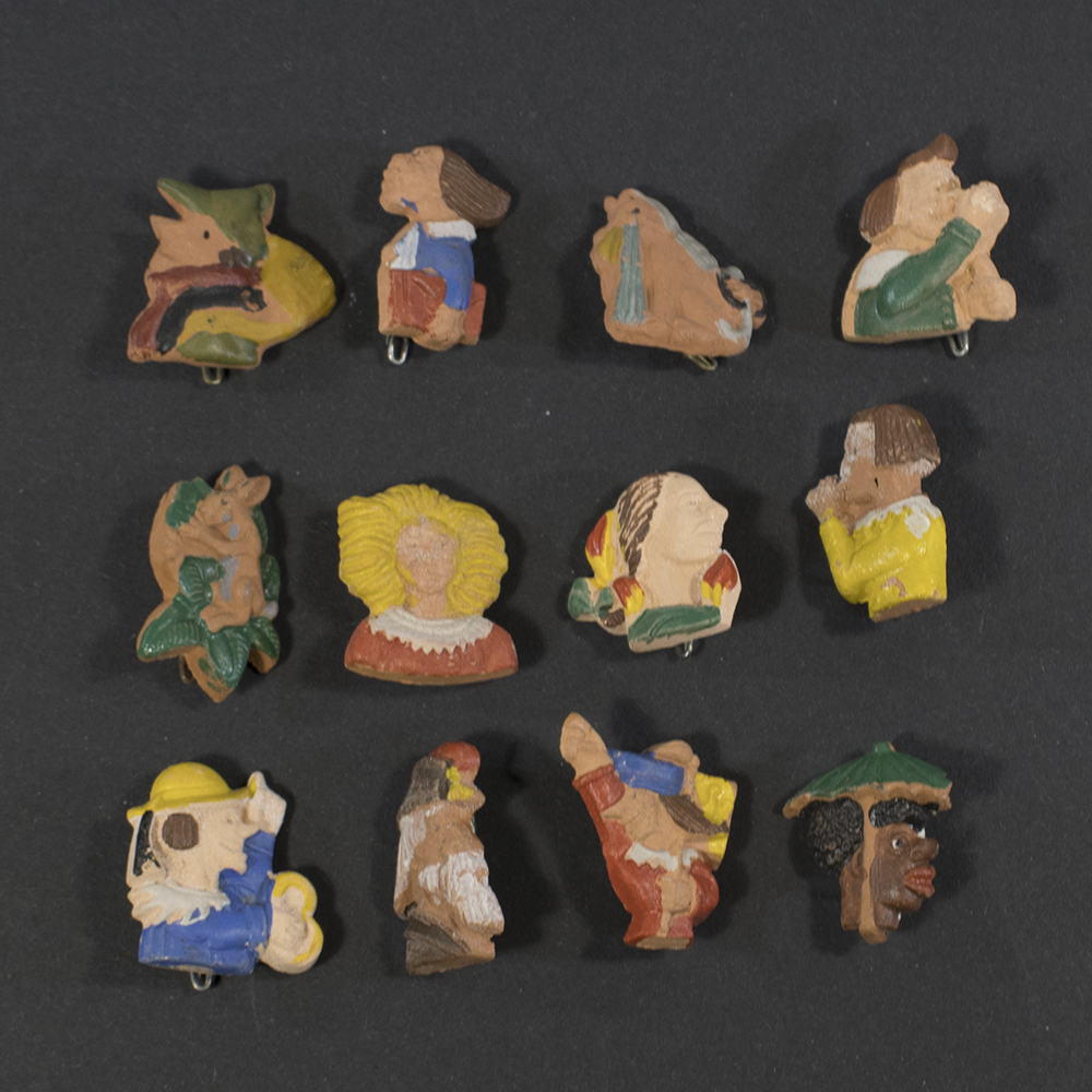 Front view of a complete set of twelve German WWII Winterhilfswerk Struwwelpeter figurines, small painted collectible figures arranged together as a matching series.