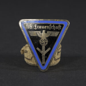 Overview of a World War II-era NS-Frauenschaft badge for local group staff, shown on a neutral background, displaying its circular shape, enamel design, and central emblem.