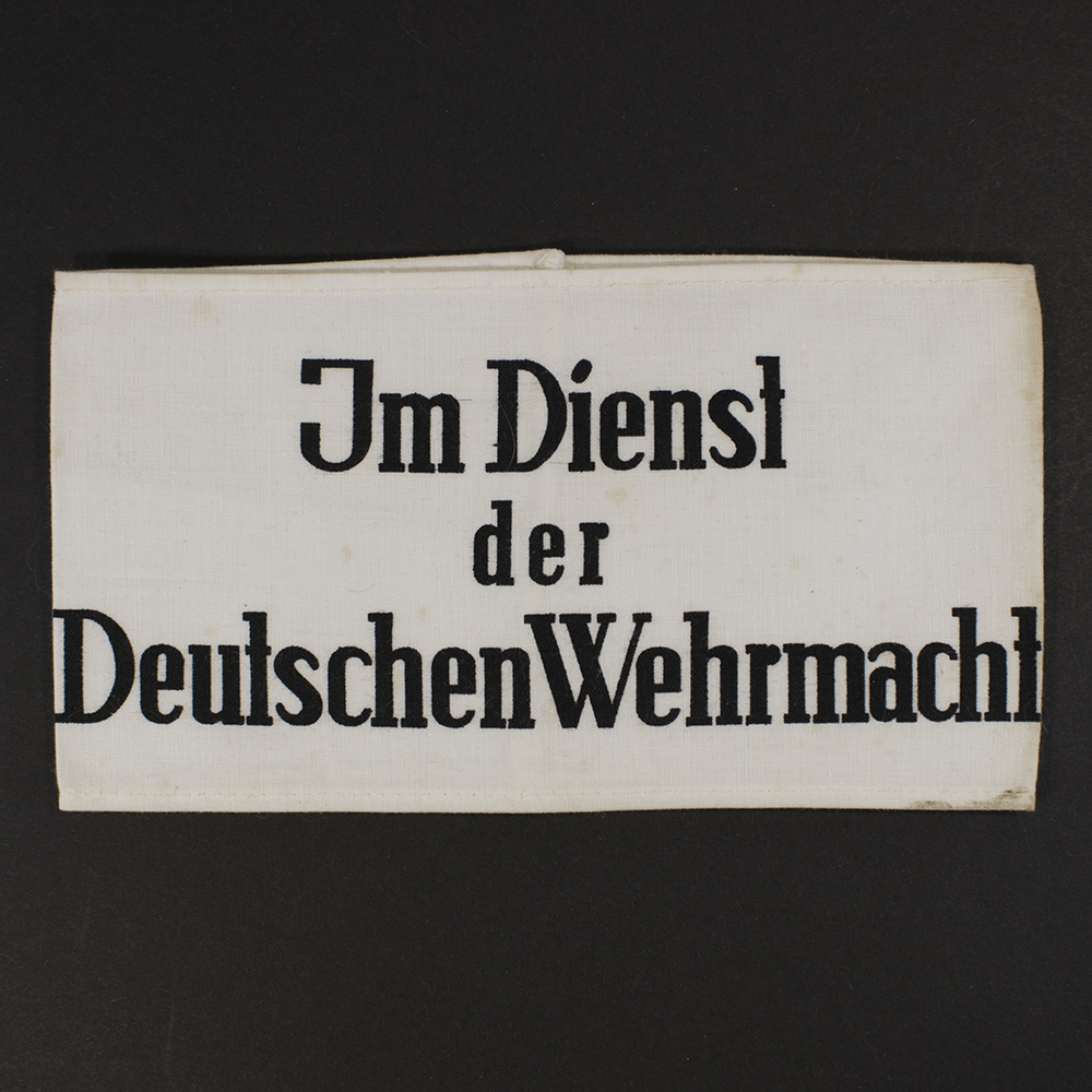Overview of 1941 German Wehrmacht civilian service armband showing white fabric with black printed text on the front.